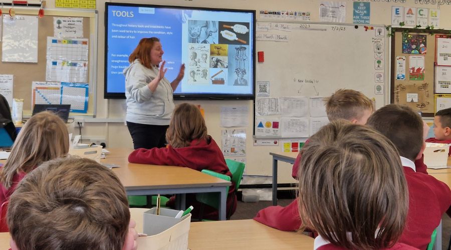 Teacher Teach a student on interactive whiteboard in the classroom