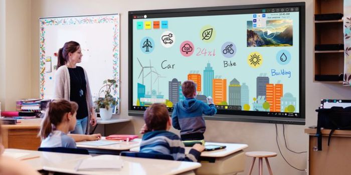 Teacher and students work on interactive flat panel display in classroom