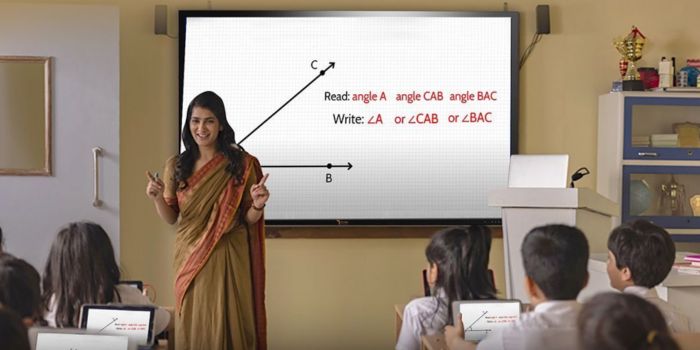 Teacher Teach a Students on interactive flat panel display in classroom